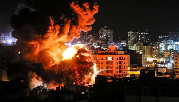 Fire and smoke billow above buildings in Gaza City yesterday during reported Israeli strikes