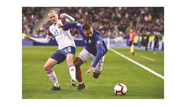 Icelandu2019s defender Ari Skulason (left) vies for the ball with Franceu2019s forward Kylian Mbappe during the UEFA Euro 2020 Group H qualification match at the Stade de France stadium in Saint-Denis, north of Paris, on Monday night. (AFP)