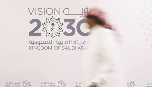 A Saudi man walks past the logo of Vision 2030 in Jeddah (file). Pharo Managementu2019s move shows lingering disquiet about the Saudiu2019s human rights record under Crown Prince Mohammed bin Salman, whose plans for economic redevelopment have been overshadowed by allegations since October that he engineered the writeru2019s brutal killing in the kingdomu2019s Istanbul consulate.