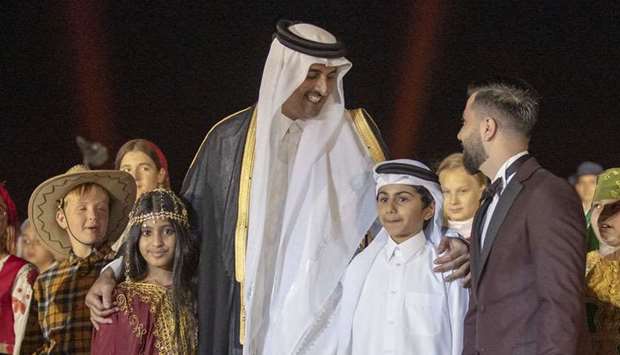 His Highness the Amir Sheikh Tamim bin Hamad al-Thani with children at the opening of the National Museum of Qatar on Wednesday.