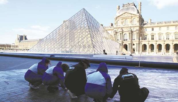 French artist JR (centre) working earlier this month in the courtyard of the Louvre Museum near the glass pyramid designed by I M Pei.