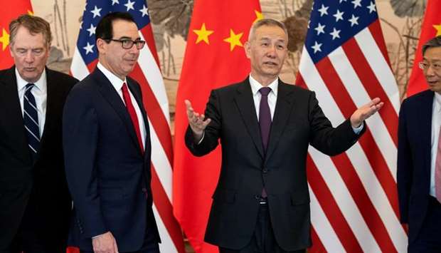 China's Vice Premier Liu He gestures next to US Treasury Secretary Steven Mnuchin and Yi Gang, governor of the People's Bank of China (PBC) as U.S. Trade Representative Robert Lighthizer looks on as they pose for a group photo at Diaoyutai State Guesthouse in Beijing