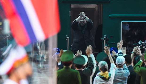 North Korea's leader Kim Jong Un (C) waves before boarding his train at the Dong Dang railway station in Lang Son