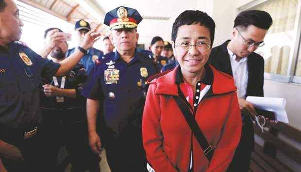 Rappler CEO and Executive Editor Maria Ressa is escorted by police after posting bail in Pasig Regional Trial Court in Pasig City, yesterday.