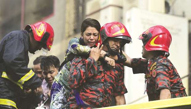 A survivor reacts after being rescued by firefighters from a burning office building in Dhaka.