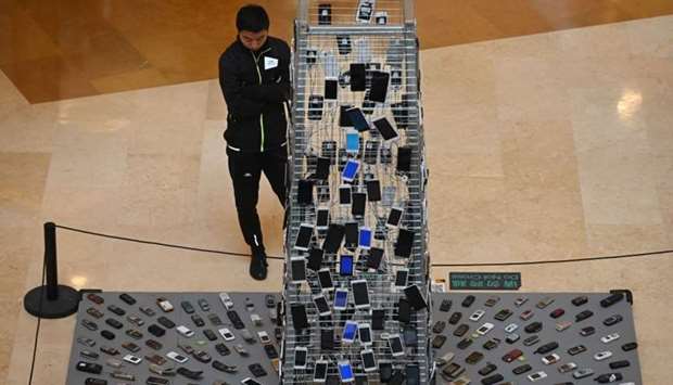 A man looks at an art installation entitled 'Tongtian' by Shen Bolun made from mobile phones at a shopping mall in Beijing