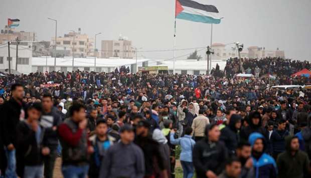 Palestinians gather during a protest marking Land Day and the first anniversary of a surge of border protests, at the Israel-Gaza border fence east of Gaza City