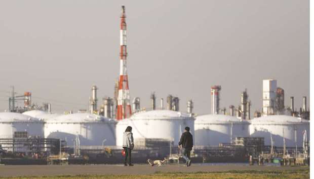 A couple walks with a dog in front of an oil refinery in the Keihin Industrial Zone in Kawasaki. Japanese refineries have put a halt on imports of Iranian oil after buying 15.3mn barrels between January and March ahead of the expiry of a temporary waiver on US sanctions, according to industry sources and data on Refinitiv Eikon.