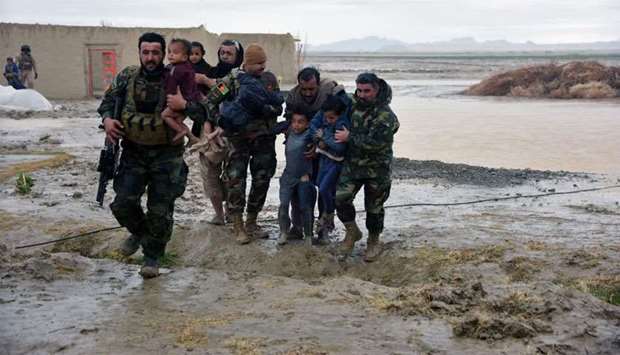 Afghan Security forces carry children after flood affected their homes in Arghandab district of Kandahar province