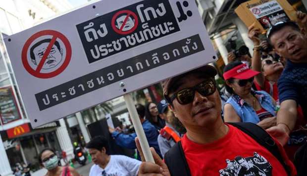 A Thai anti-junta protester displays a placard during a demonstration in Bangkok disputing results of the country's first general election since a 2014 coup