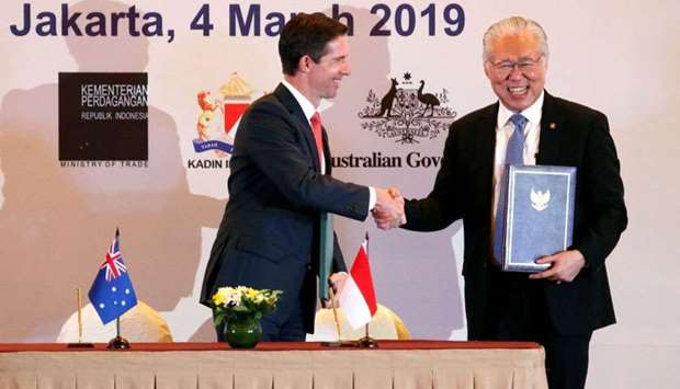 Indonesia's Trade Minister Enggartiasto Lukita and Australia's Minister of Trade, Tourism and Investment Simon Birmingham shakes hands after signing an economic partnership agreement aimed at boosting trade and investment in Jakarta