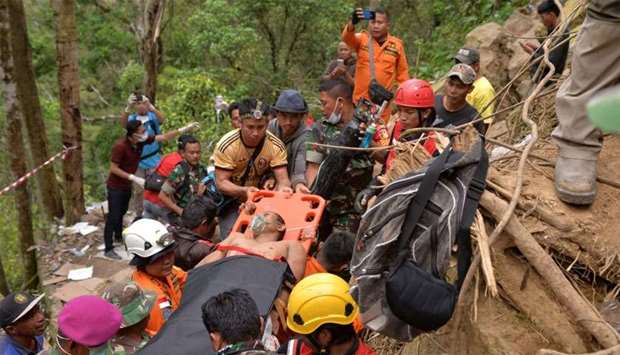 Members of an Indonesian search and rescue team carry a survivor after a mine collapsed in Bolaang Mongondow, North Sulawesi