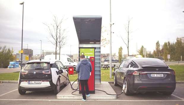 Electric automobiles manufactured by Bayerische Motoren Werke AG, left, and Tesla Inc sit at an electric vehicle charging station at a Circle K gas station, operated by Alimentation Couche-Tard Inc, in the Oekern district of Oslo, Norway, in this October 31, 2017 file picture. Couche-Tard is using the Nordic country as a testing ground for how to respond to the  electric-vehicle boom.u00a0Photographer: Kyrre Lien/Bloomberg