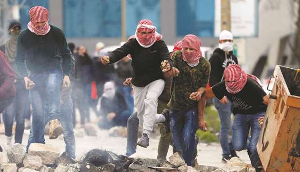 Palestinians run during clashes with Israeli forces near the settlement of Beit El, near Ramallah, in the Israeli-occupied West Bank, yesterday.