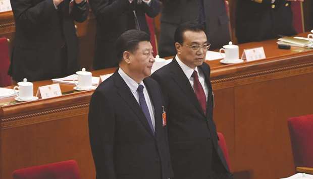 Chinau2019s President Xi Jinping (left) and Premier Li Keqiang are applauded as they arrive for the opening session of the National Peopleu2019s Congress (NPC) at the Great Hall of the People in Beijing yesterday.
