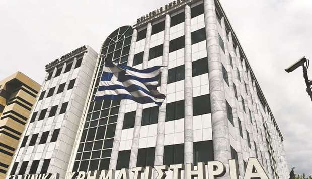 A Greek flag waves outside the Athens Stock Exchange (file). The benchmark stock index edged 0.5% higher yesterday, snapping two days of losses.