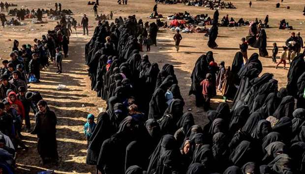 Civilians evacuated from the Islamic State (IS) groupu2019s embattled holdout of Baghouz wait at a screening area held by the US-backed Kurdish-led Syrian Democratic Forces (SDF), in the eastern Syrian province of Deir Ezzor.