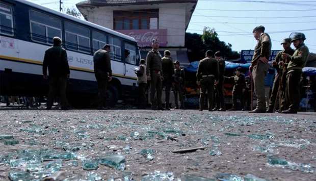 Indian police inspect the site of a grenade blast at a bus station in Jammu