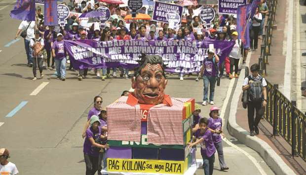 Activists from Gabriela push a carriage with an effigy of President Rodrigo Duterte as they march towards Malacanang palace.