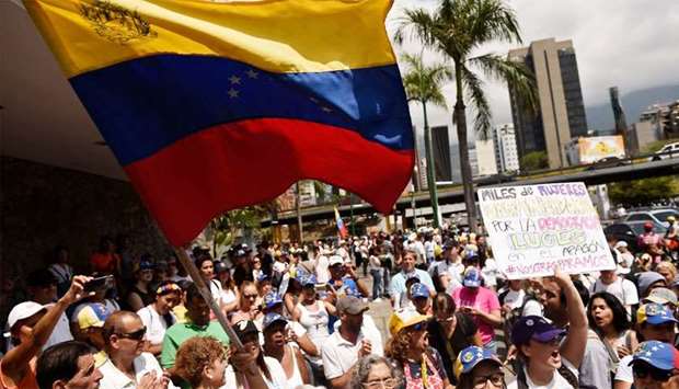 Supporters of Venezuelan opposition leader and self-proclaimed acting president Juan Guaido, demonstrate with a Venezuelan national flag