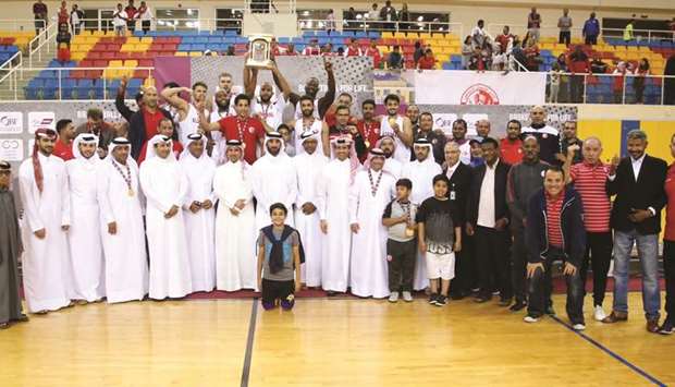 Al Shamal players and officials celebrate with the trophy after winning the Qatar Menu2019s League basketball yesterday.