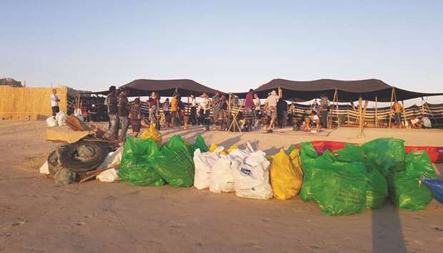 Sacks of collected waste materials arranged at a camp site.