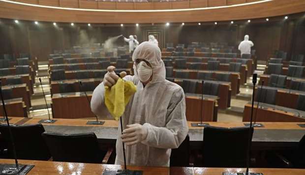 Sanitary workers disinfect the desks and chairs of the Lebanese Parliament in central Beirut