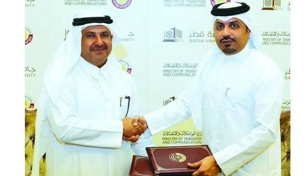 MOTC's Acting Assistant Undersecretary of Land Transport Affairs Engineer Hamad Essa Abdulla and Dean of QU College of Engineering Dr Khaled Kamal Naji exchange documents after signing the memorandum.