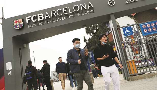 Chinese student Gao Jia Xin and another man walk outside the Camp Nou after FC Barcelona announced that their Champions League match versus Napoli will be played behind closed doors.