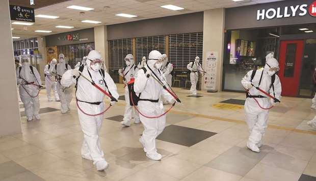 South Korean soldiers wearing protective gear sanitise Daegu railway station in Daegu, yesterday.