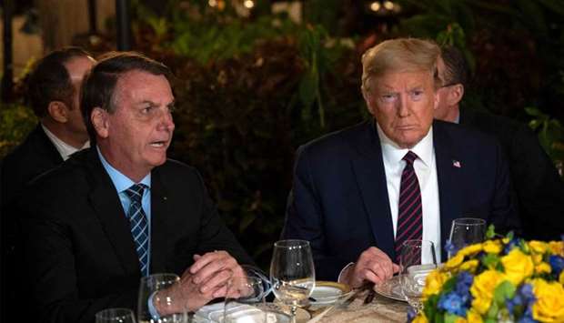 In this file photo US President Donald Trump (R) speaks with Brazilian President Jair Bolsonaro during a dinner at Mar-a-Lago in Palm Beach, Florida, on March 7, 2020.
