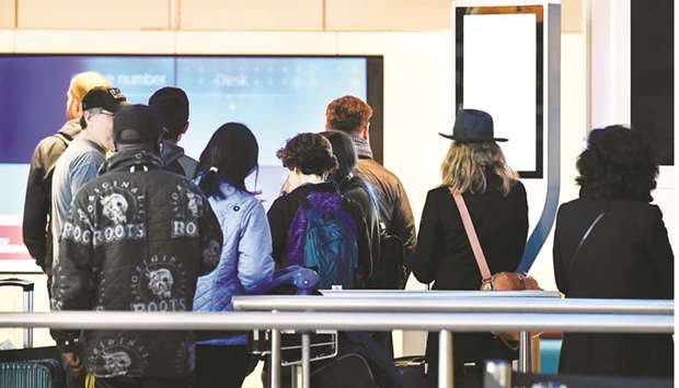 Travellers wait to be informed in the departure hall at the KLM Service Desk, as the travel ban for European countries announced by US President Donald Trump has major consequences for the world of travel and travellers that have just arrived from US, in Schiphol, Netherlands yesterday.