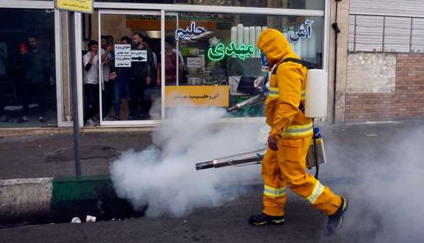 An Iranian firefighter disinfects a street in the capital Tehran in a bid to halt the spread of coronavirus, yesterday.