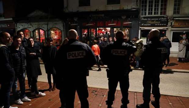 Police officers speak to customers as they control the closure of a cafe at midnight in Le Touquet yesterday