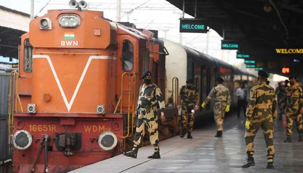 Indian security personnel wearing facemasks amid concerns over the spread of the COVID-19 novel coronavirus, stand guard at the platform upon arrival of the ,Maitree Express, train, which connects Dhaka in Bangladesh to India, in Kolkata
