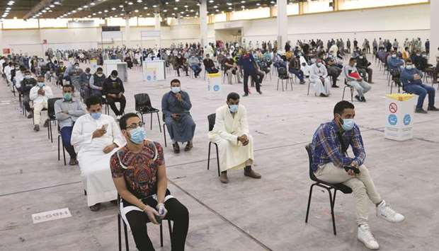 Expatriates wait for mandatory coronavirus testing in a makeshift testing centre in Mishref, Kuwait, yesterday.