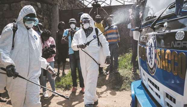 Health workers wearing protective gear disinfect the minibus of the first Kenyan patient of the Covid-19 in Ongata Rongai, neighbouring town of Nairobi, yesterday.