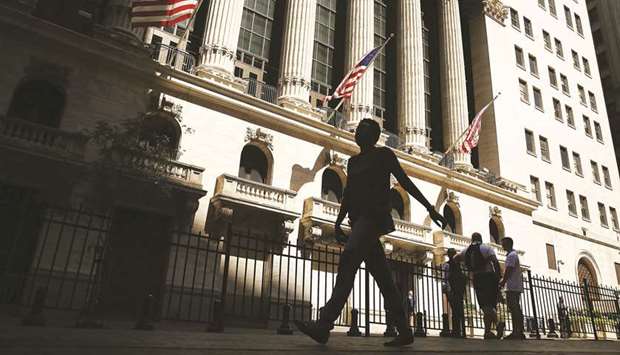 People walk by the New York Stock Exchange. The evaporation of liquidity was evident across virtually all asset classes on Wall Street, but its absence was most stark in securities which normally serve as havens and see their prices increase during a turmoil.