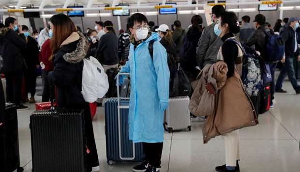 Passengers waiting to check in for an Air China flight are seen with face masks on, after further cases of coronavirus were confirmed in New York, at JFK International Airport in New York
