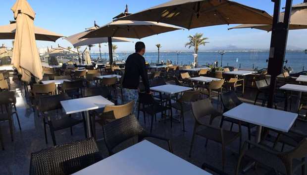 A waiter gazes at the sea from an empty restaurant in the Tunisian capital Tunis, yesterday, after the governmentu2019s decision to shut down bars, cafes and restaurants in a bid to limit the spread of the coronavirus.