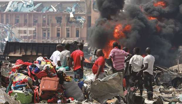 People gather with their belongings at the scene of the fire outbreak at Abule-Ado in Lagos, yesterday.