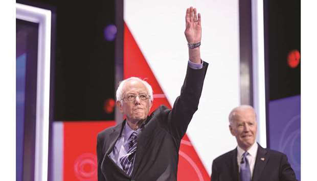 This photo taken on February 25 shows Sanders (left) and Biden arriving on stage for the tenth Democratic primary debate of the 2020 presidential campaign season, in Charleston, South Carolina.