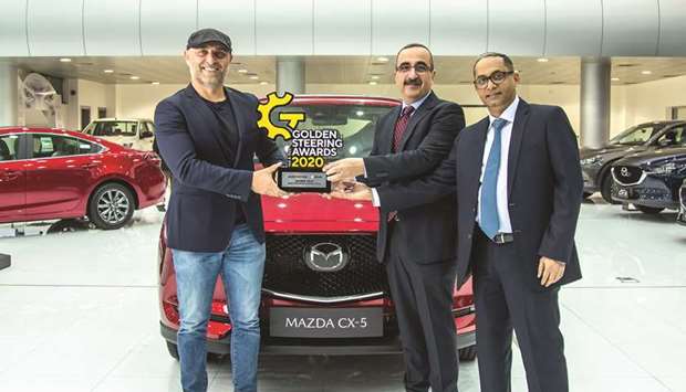 Officials pose with the award in front of the Mazda CX-5.