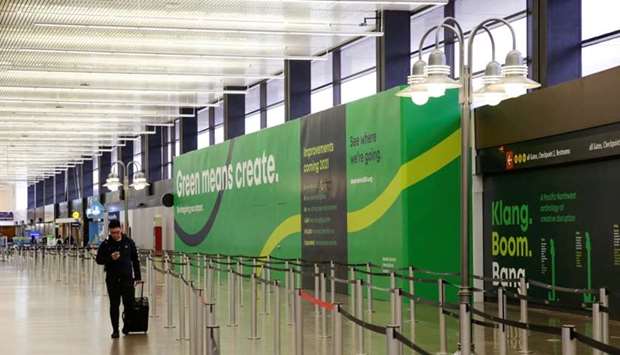 A traveler walks past empty security lines at Seattle-Tacoma International Airport, in SeaTac, Washington, US,  as airlines are reeling from a plunge in bookings and traffic, as the fast-spreading coronavirus pandemic prompts travel restrictions and event cancellations around the world