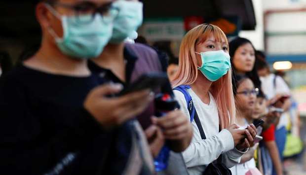 Commuters wait for a transport to leave the Woodlands Causeway across to Singapore from Johor, hours before Malaysia imposes a lockdown on travel due to the coronavirus outbreak on Tuesday.