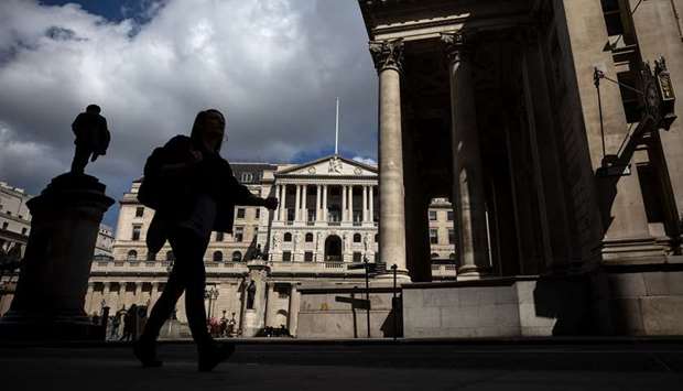 A pedestrian walks past the Bank of England in the City of London. Joining other central banks in stepping up action over the virus, the BoE has also increased holdings of UK government and corporate bonds to u00a3645bn ($766bn, u20ac700bn).