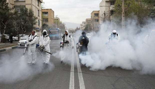 Members of firefighters wear protective face masks, amid fear of coronavirus disease, as they disinfect the streets, ahead of the Iranian New Year Nowruz, in Tehran, Iran.