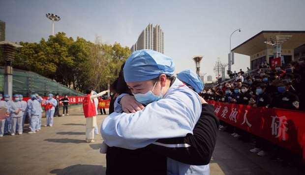 A medical worker embraces a member of a medical assistance team from Jiangsu province at a ceremony marking their departure after helping with the coronavirus recovery effort, in Wuhan, in Chinau2019s central Hubei province yesterday