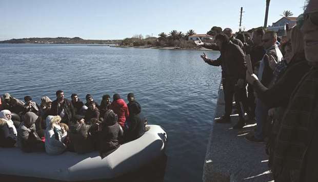 Migrants are seen on an inflatable boat as local residents of Lesbos island prevent them from landing.