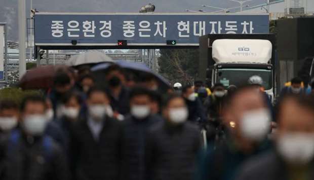 Employees wearing masks to prevent the coronavirus walk at a Hyundai Motors factory in Ulsan, South Korea